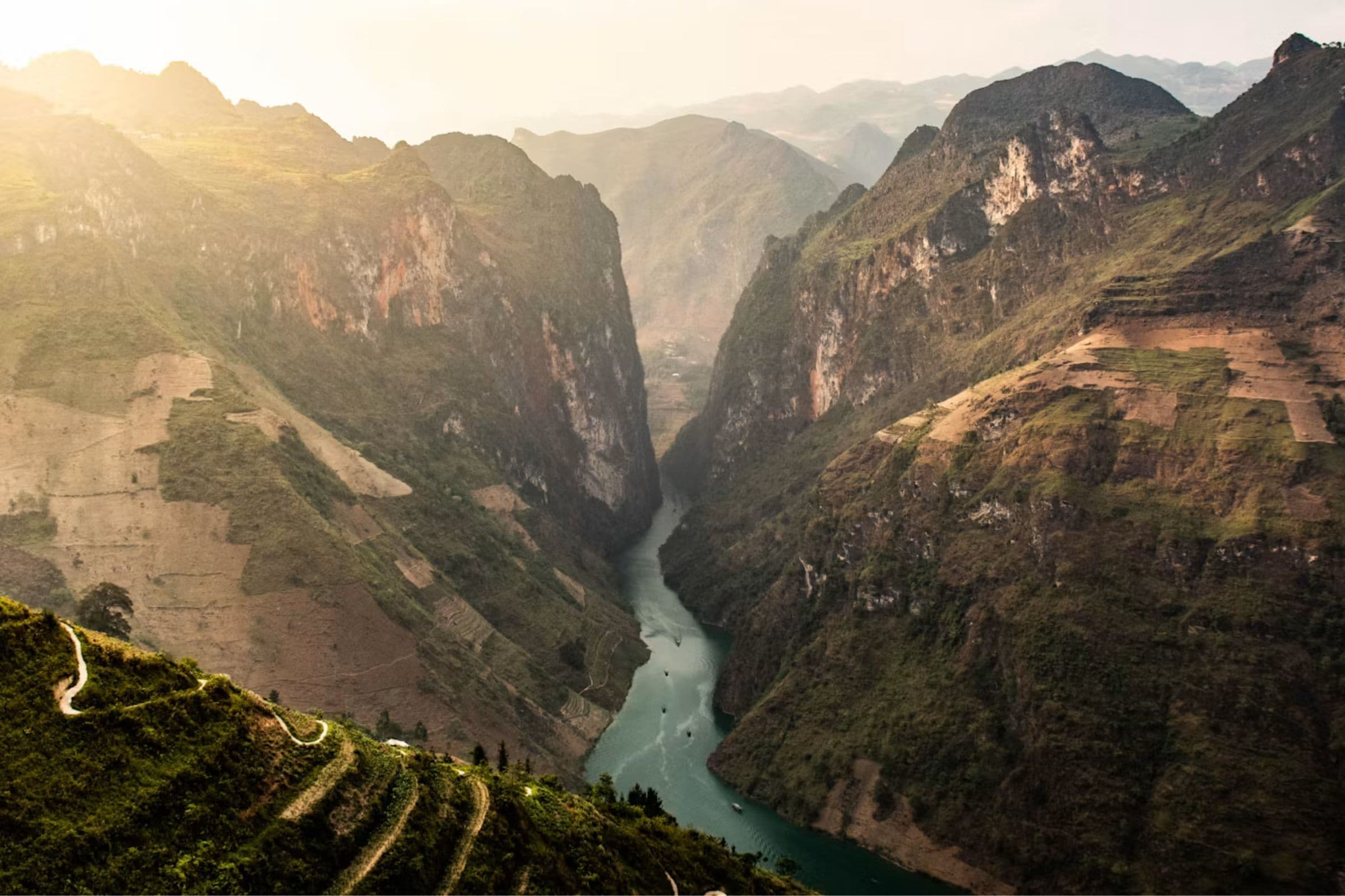 A mountain road winding through the limestone peaks of the Ha Giang Loop, Northern Vietnam